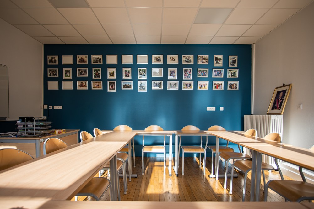 Salle de la section norv&eacute;gienne, mur bleu couvert de photographies de promotions