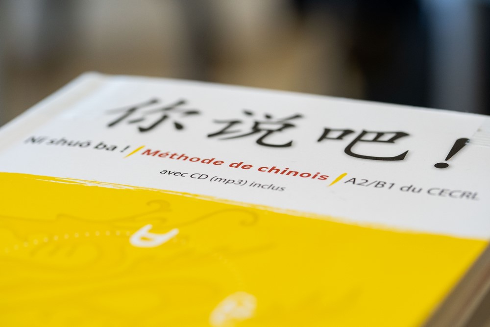 Manuel de chinois ouvert sur une table de travail