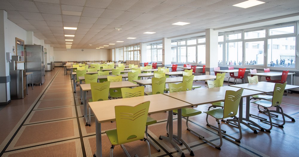 Salle du restaurant scolaire avec ses tables et ses chaises color&eacute;es